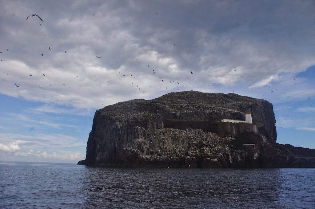 Bass rock with blue sky and clouds behind