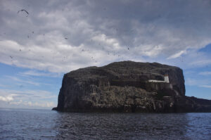 Bass rock with blue sky and clouds behind